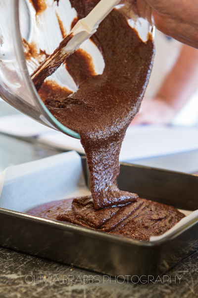 chocolate brownie mixture being poured into baking tin