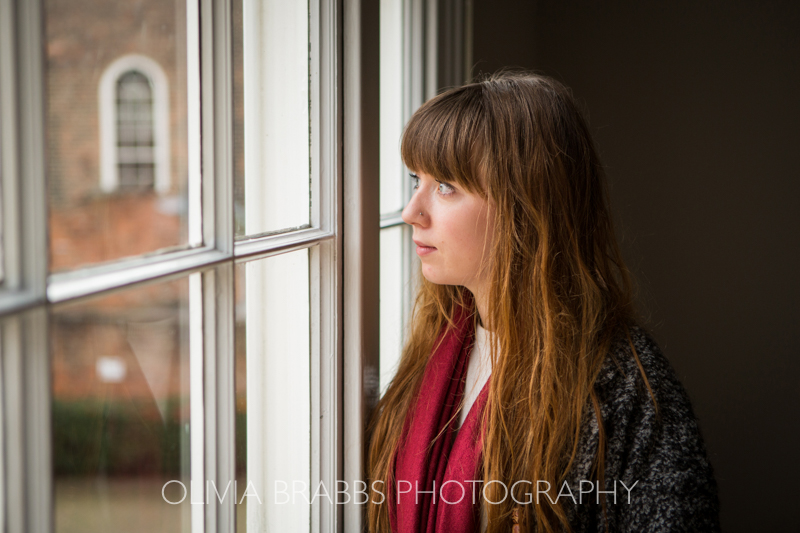young woman at window portrait for domestic abuse charity awareness campaign