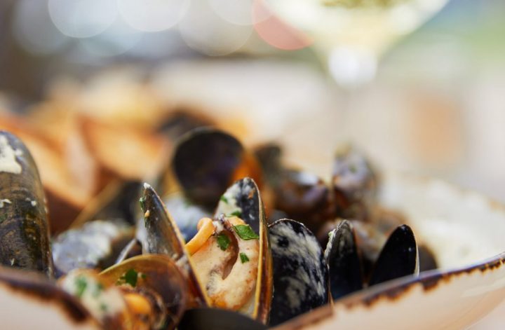 seafood restaurant photography of mussels and a glass of white wine