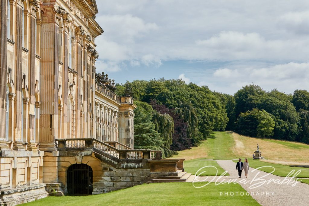 Visitors walking alongside Castle Howard to show scale and grandeur of the property