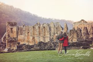 couple standing together looking over Rievaulx Abbey in North York Moors National Park