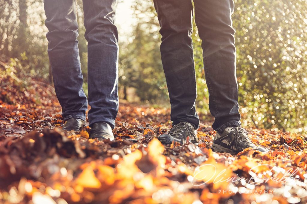 couple walking in autumnal leaves showing boots and legs