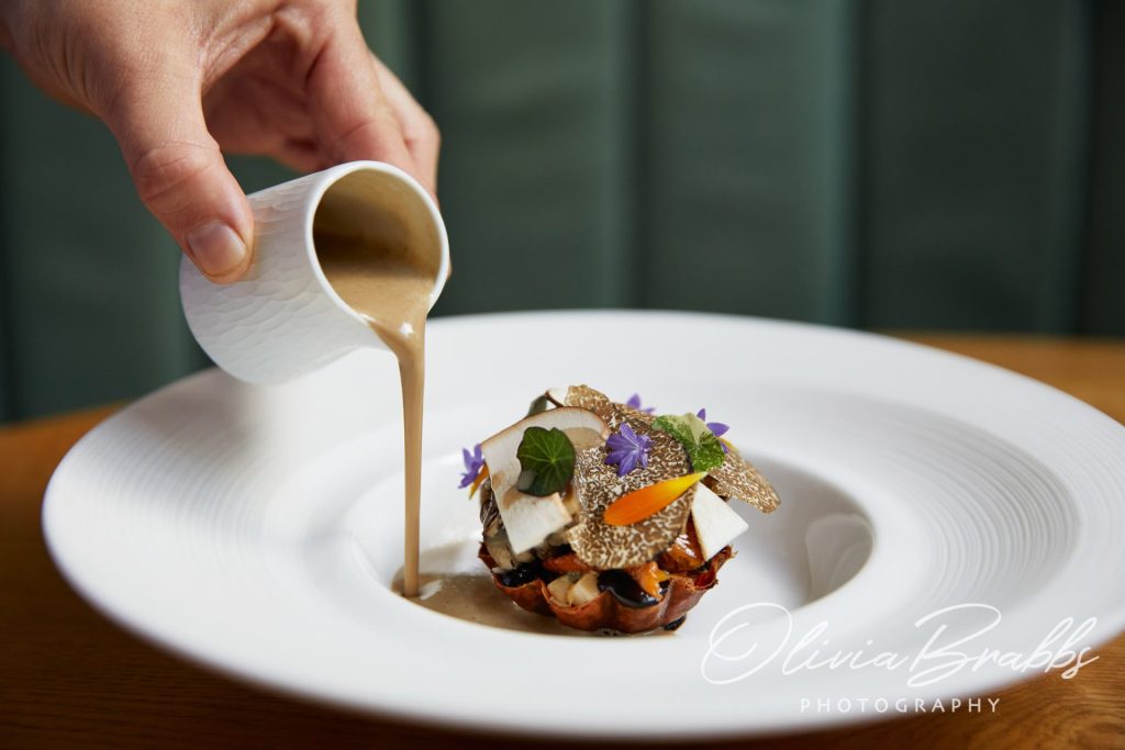close up food photograph of signature mushroom dish at Cail Bruich in Glasgow showing sauce being poured