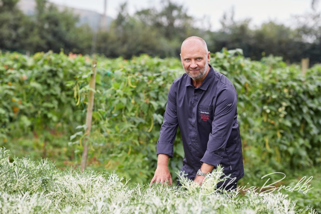Michelin starred chef Simon Rogan photographed against crops at Our Farm that supplies his restaurant L'Enclume