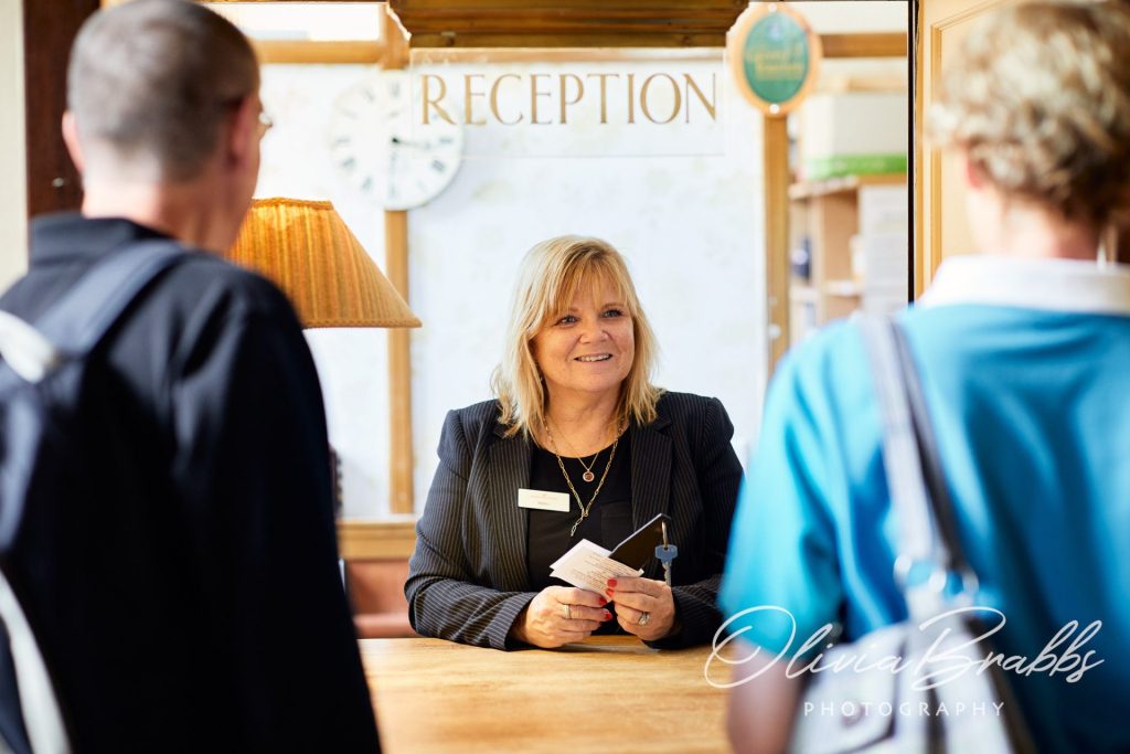 lifestyle photography for hotel showing receptionist greeting guests